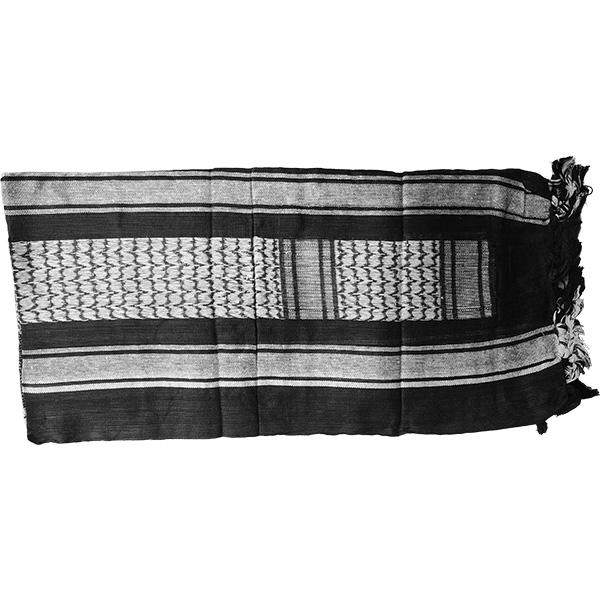 Tactical shemagh scarf with pirate skull design used outdoors in a desert setting.